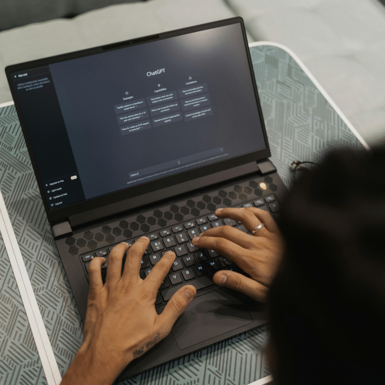 Hands typing on a laptop with ChatGPT interface open.
